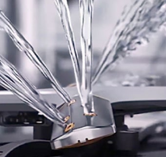 Intense water streams from dishwasher blades in close-up.