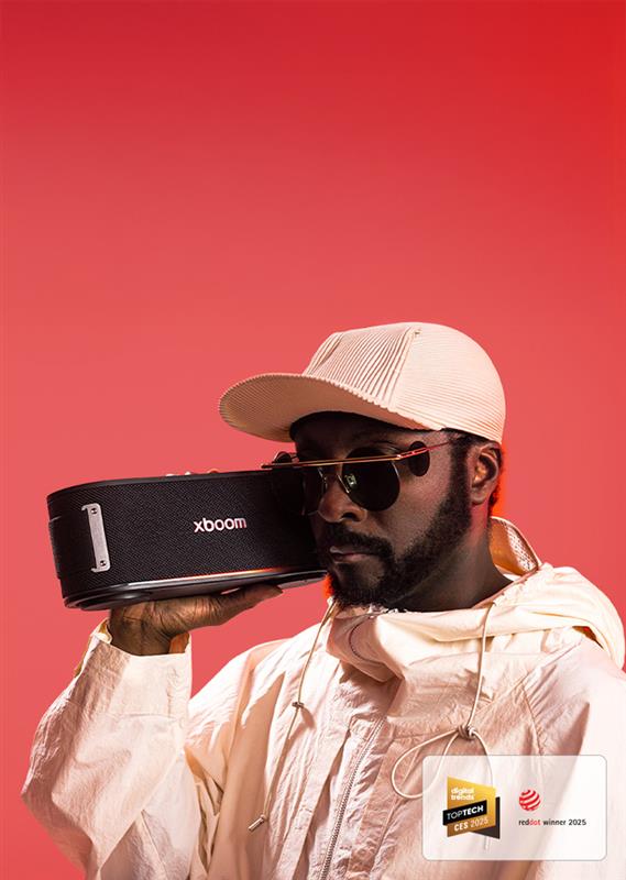 will.i.am in white outfit and sunglasses is holding xboom Bounce right next to his face.	