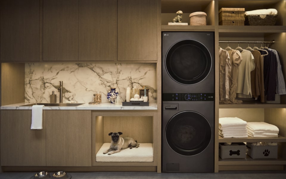 LG WashTower black washer dryer in modern laundry room with shelves.