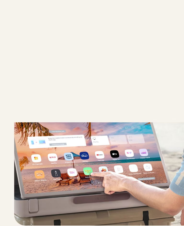 Zoom du LG StanbyME Go. Le produit est placé sur une table et l’écran pivoté à l’horizontale. Une main touche une ic?ne.