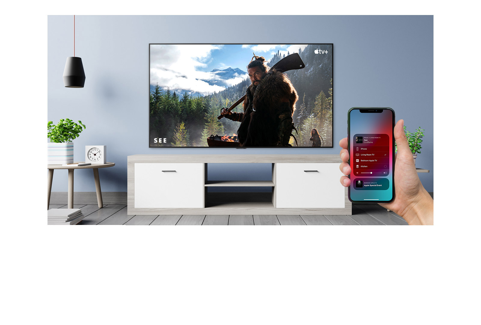 Gros plan d’une main contr?lant le téléviseur avec un iPhone et du téléviseur affichant un contenu Apple TV+