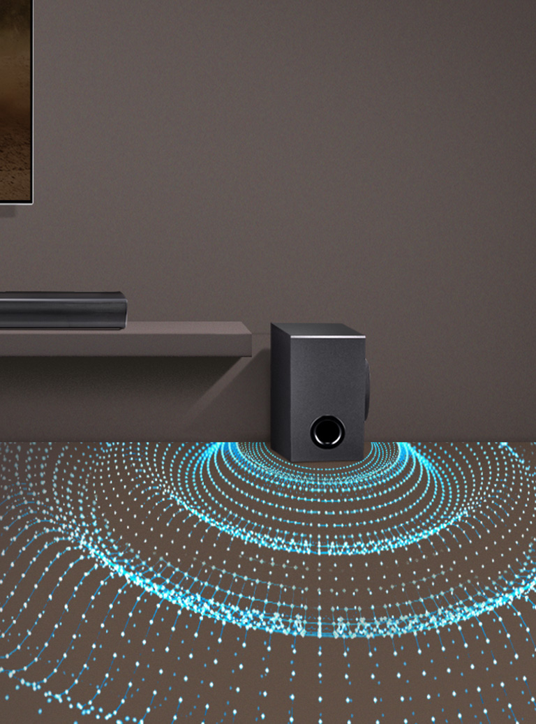 Dans le salon, le téléviseur LG est accroché au mur. La barre de son LG SQC1 est placée en dessous du téléviseur. Un caisson de basses sans fil est placé sur la droite Des ondes sonores sortent en dessous du caisson de basses pour en illustrer la puissance.