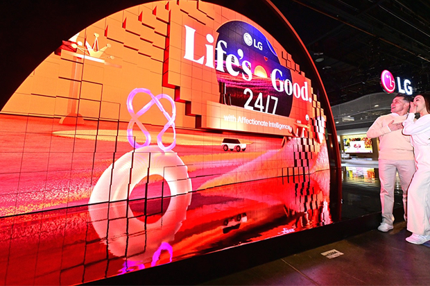 Les visiteurs admirent l'écran LED incurvé de LG arborant le slogan ? Life's Good 24/7 ? lors d'une exposition technologique