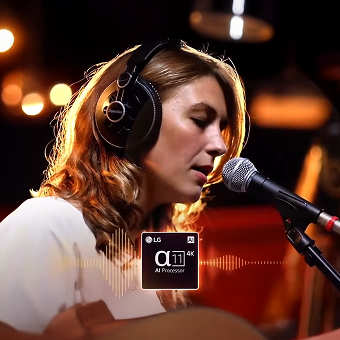 Femme chantant dans un microphone avec un casque, mise en valeur par l'amélioration du son du processeur LG α11 AI
