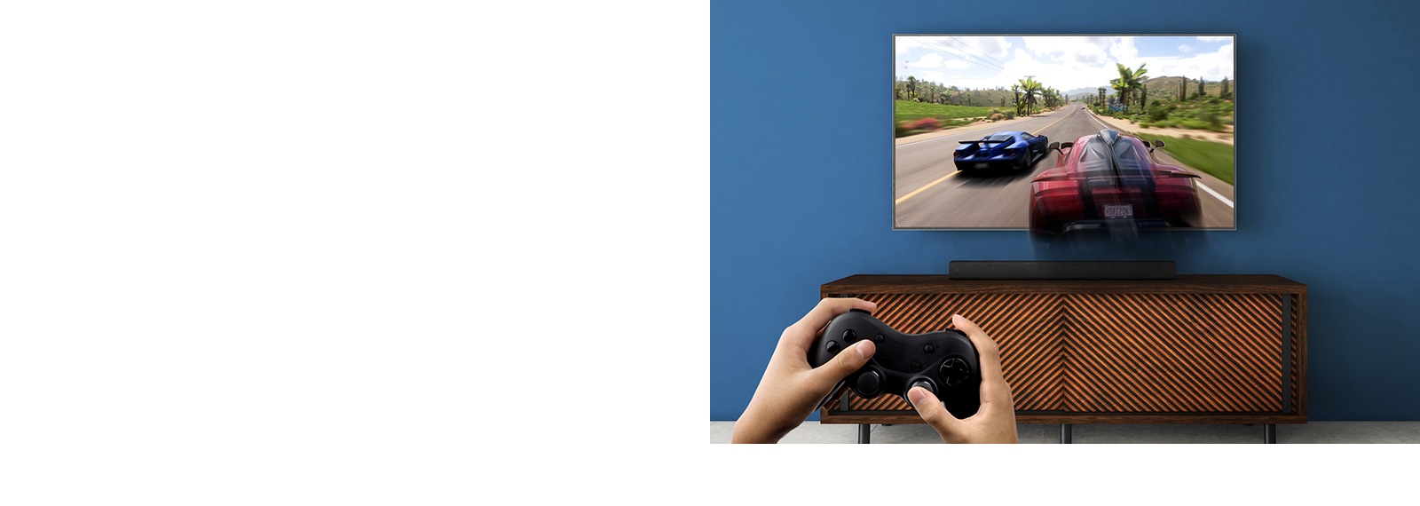 Un téléviseur LG est installé au mur, montrant un jeu de course. La barre de son LG est installée sur l’étagère marron, juste en dessous du téléviseur LG. Un homme tient un joystick. La marque NEW est affichée dans le coin supérieur gauche.