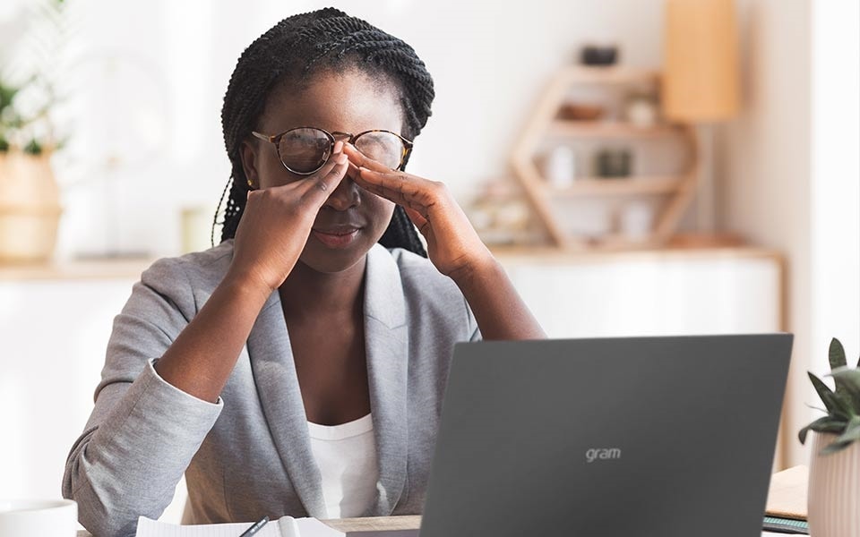 Une femme repose ses yeux pour éviter la fatigue oculaire.