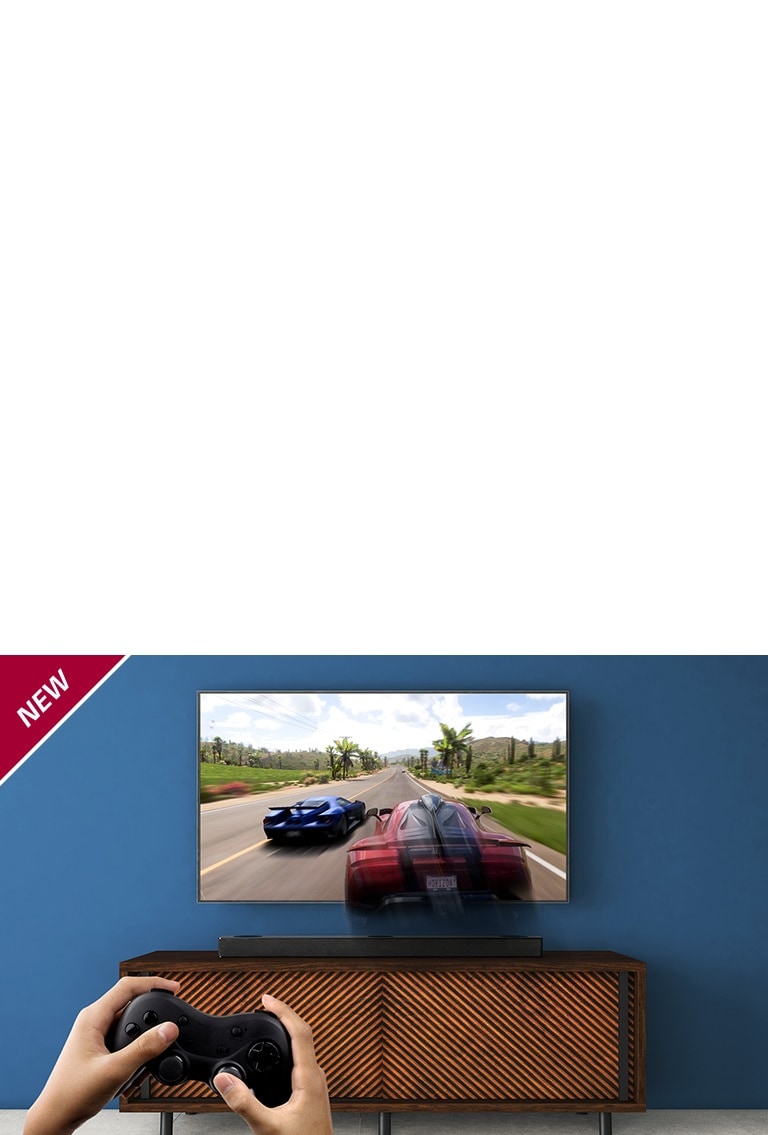 El televisor LG está en la pared, mostrando un juego de carreras. La barra de sonido LG se encuentra en el estante marrón, justo debajo del televisor LG. Un hombre sostiene un joystick. Se muestra la marca NUEVA en la esquina superior izquierda