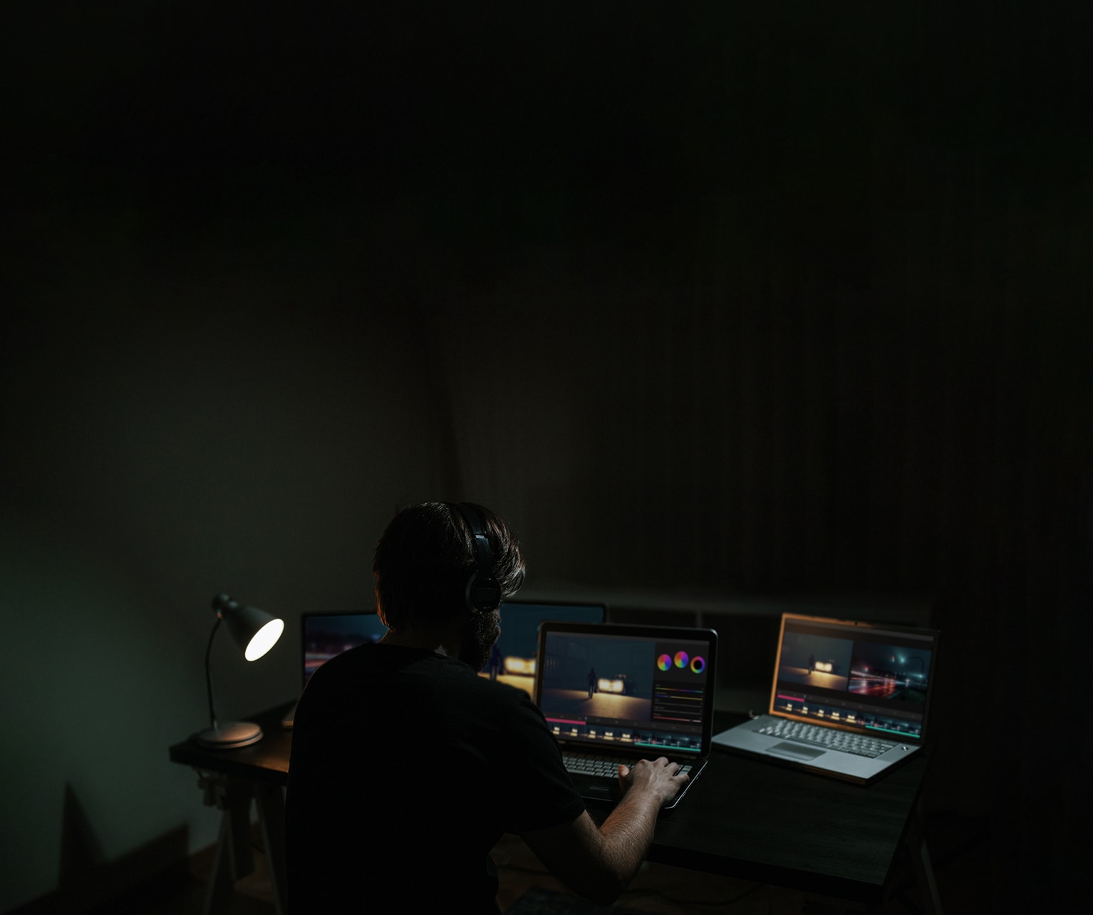 Un hombre edita una película mientras mira el software en el monitor de un ordenador