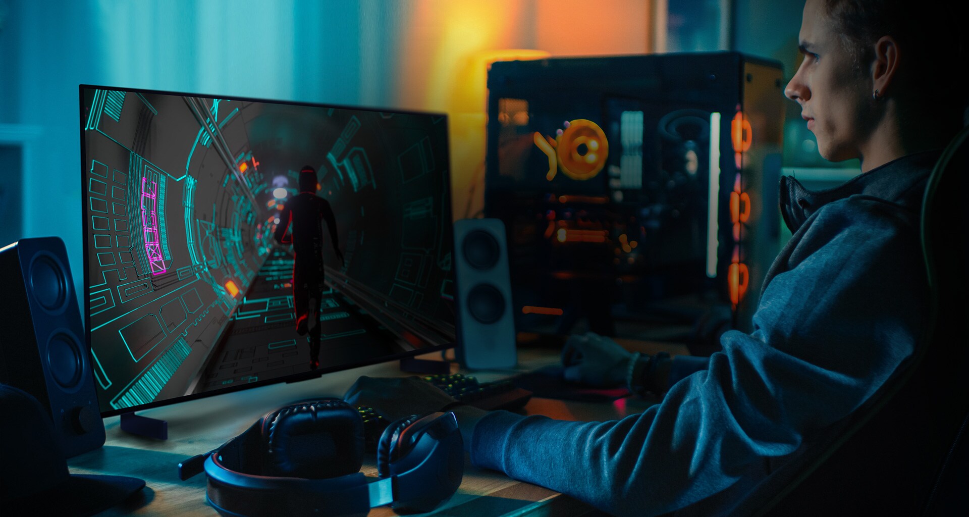 Una persona juega a un juego de ciencia ficción en su escritorio personal en un peque?o televisor LG OLED