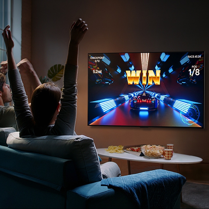 Un grupo de gente juega una partida con un controlador en el televisor LG OLED