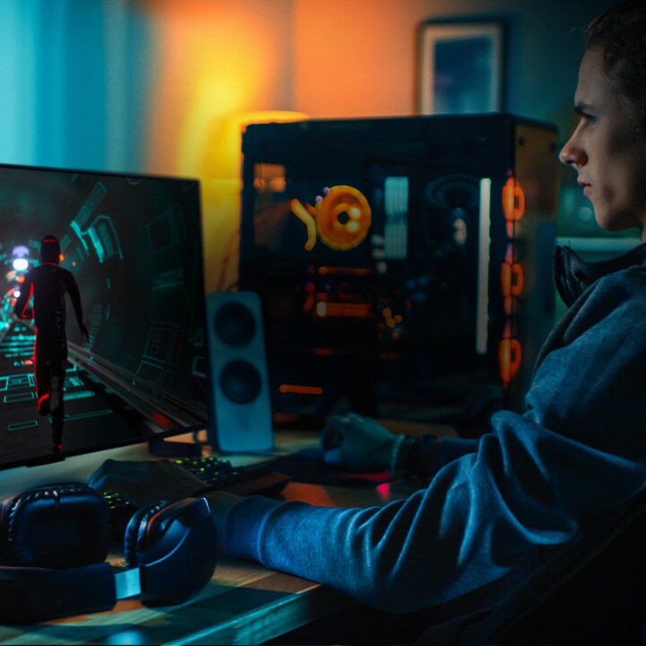 Una persona juega a un juego de ciencia ficción en su escritorio personal en un peque?o televisor LG OLED