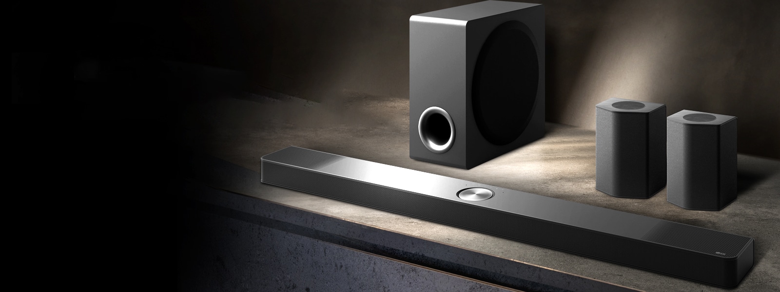 LG Soundbar、后置揚聲器和低音炮（傾斜視圖）位于黑色房間的褐色木架，籠罩在黑暗中，光線只照在音箱系統。