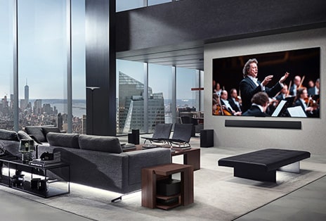 Wohnzimmer mit einem LG True Wireless TV und einer LG Soundbar, die an der Wand befestigt ist. Die Zero Connect Box ist unter einem Beistelltisch neben der Couch kaum zu sehen?– sie l?sst sich praktisch überall aufstellen. Das gesamte Layout des Wohnzimmers wirkt ordentlich und aufger?umt.