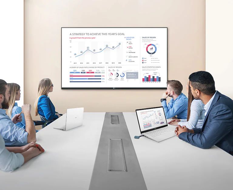 Ein Meeting findet statt, indem ein USB-Dongle-Ger?t an ein Laptop angeschlossen wurde und der Bildschirminhalt auf einem gro?en Signage-Display an der Wand wiedergegeben wird.