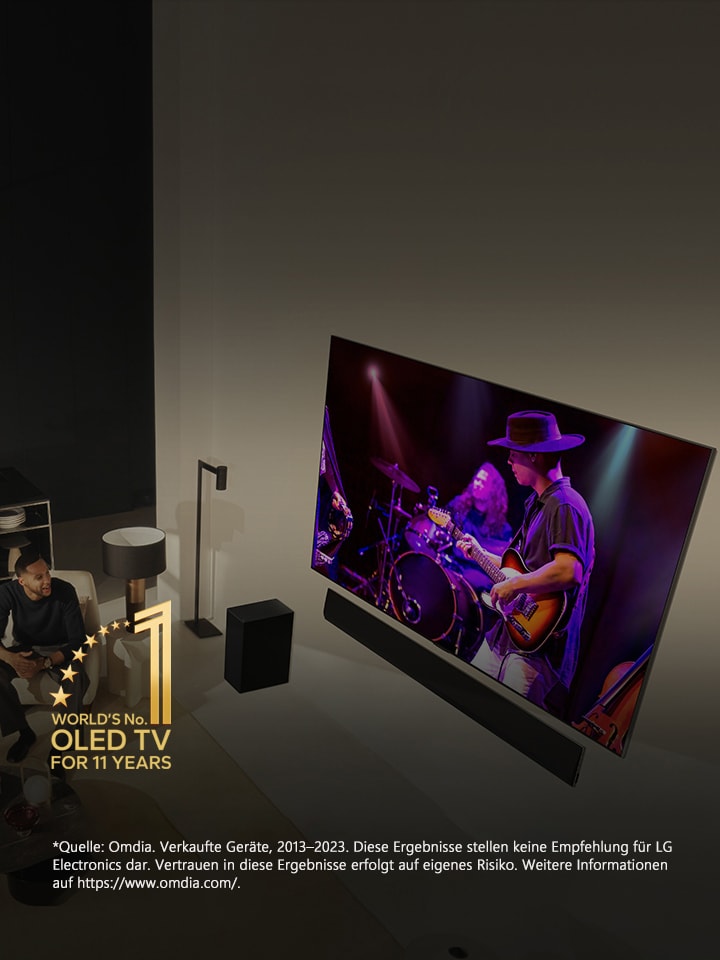 Eine Luftaufnahme von einem Mann und einer Frau, die in einer modernen Wohnung auf einem gro?en OLED TV ein Konzert ansehen. Das Gütesiegel ?11?Jahre weltbester OLED TV“ ist auf dem Bild erkennbar. Im Haftungsausschluss hei?t es wie folgt: ?Quelle: Omdia. Verkaufte Ger?te, 2013–2023. Diese Ergebnisse stellen keine Empfehlung für LG Electronics dar. Vertrauen in diese Ergebnisse erfolgt auf eigenes Risiko. Weitere Informationen auf?https://www.omdia.com/.“	