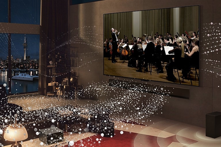 Ekrane rodomas koncertas, o i? LG OLED evo M4 ir LG Soundbar po kambar? sklinda balti apskritimai.