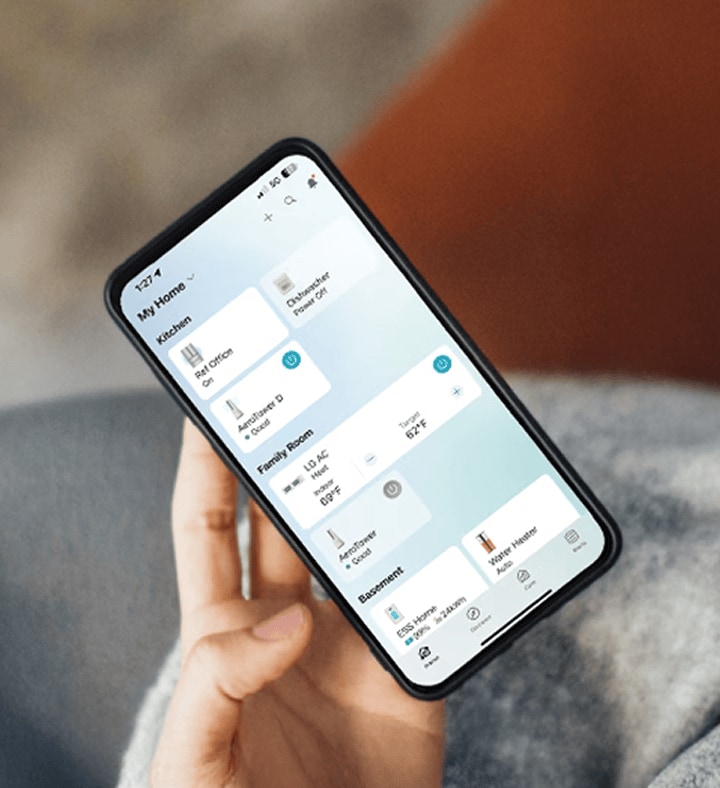 Eine Person h?lt ein Smartphone mit ge?ffneter LG ThinQ App und steuert w?hrend des Kaffeetrinkens smarte Haushaltsger?te.