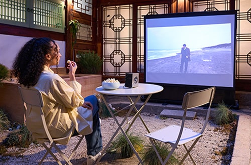 Ein Gast schaut sich einen Film an, der mit einem Beamer auf eine Leinwand projiziert wird.