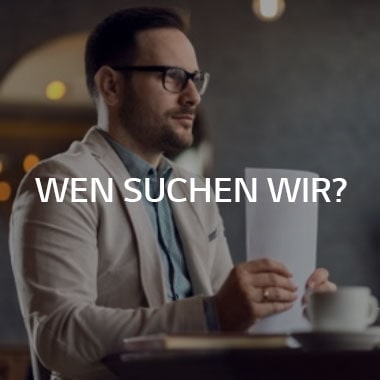 Ein Mann sitzt an einem Schreibtisch und h?lt einen Papierstapel
