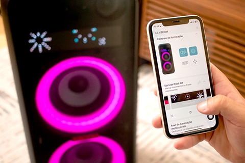 Homem operando o alto-falante LG XBoom com o aplicativo móvel. Ele está configurando a ilumina??o colorida e artes de pixel via aplicativo móvel.