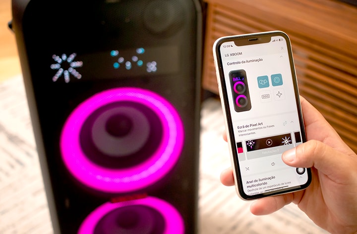 Homem operando o alto-falante LG XBoom com o aplicativo móvel. Ele está configurando a ilumina??o colorida e artes de pixel via aplicativo móvel.