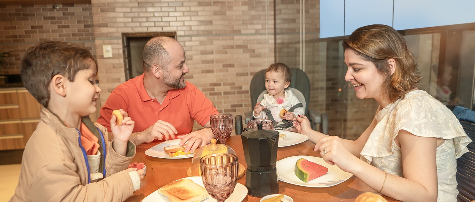A família juntou-se à mesa, compartilhando uma refei??o com sorrisos na cara.