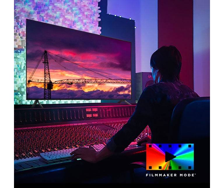 Um homem em um estúdio de edi??o escuro olhando para uma LG TV exibindo o p?r do sol. No canto inferior direito da imagem está o logotipo do FILMMAKER Mode.