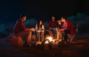 Pessoas curtindo um acampamento com sorrisos, abra?ando o poder do otimismo.