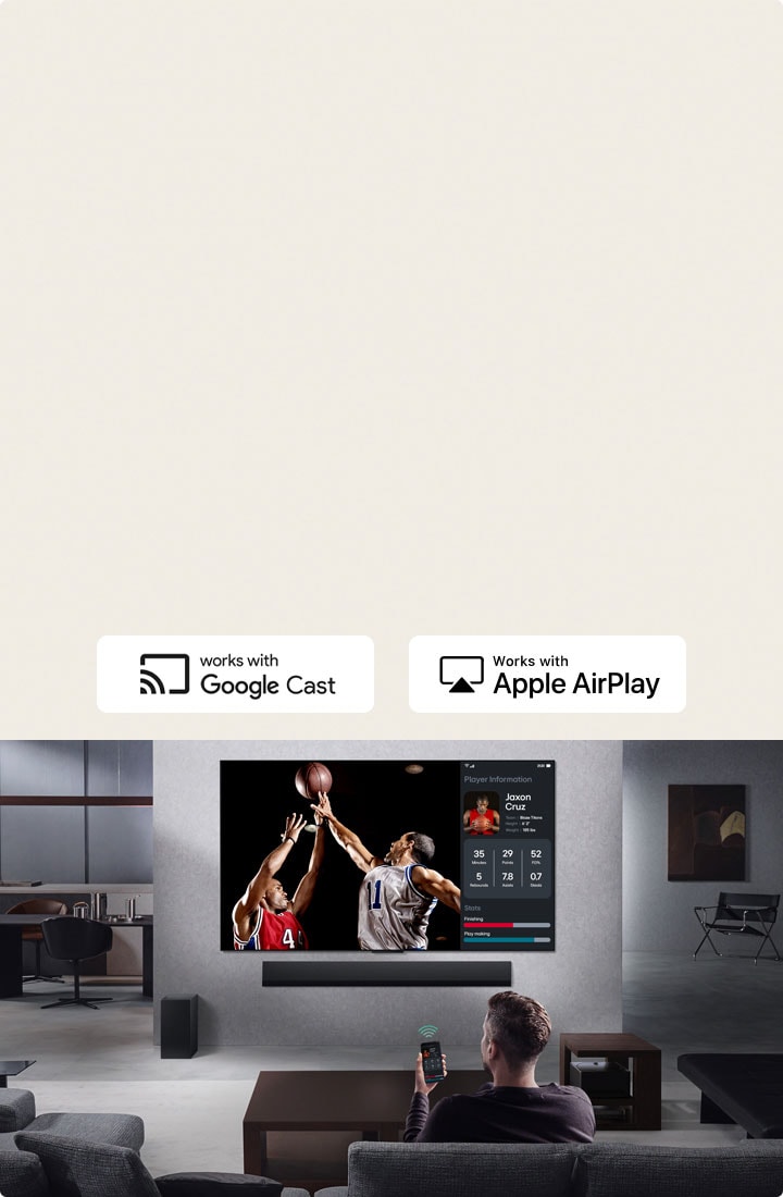 Personne dans son salon tenant son téléphone. Sur le téléphone se trouve une ic?ne de transmission indiquant que l’écran du téléphone est reflété sur le téléviseur. Un match de basket-ball est diffusé sur le téléviseur. Sur le c?té, un écran miroir affiche les statistiques des joueurs. 