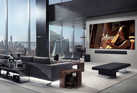 Salon avec un téléviseur sans fil de LG et une LG Soundbar fixée au mur. La Zero Connect Box est à peine visible sous une table d’appoint près du canapé, ce qui montre qu’elle peut facilement être placée n’importe où. Toute la disposition du salon est visuellement soignée et ordonnée.