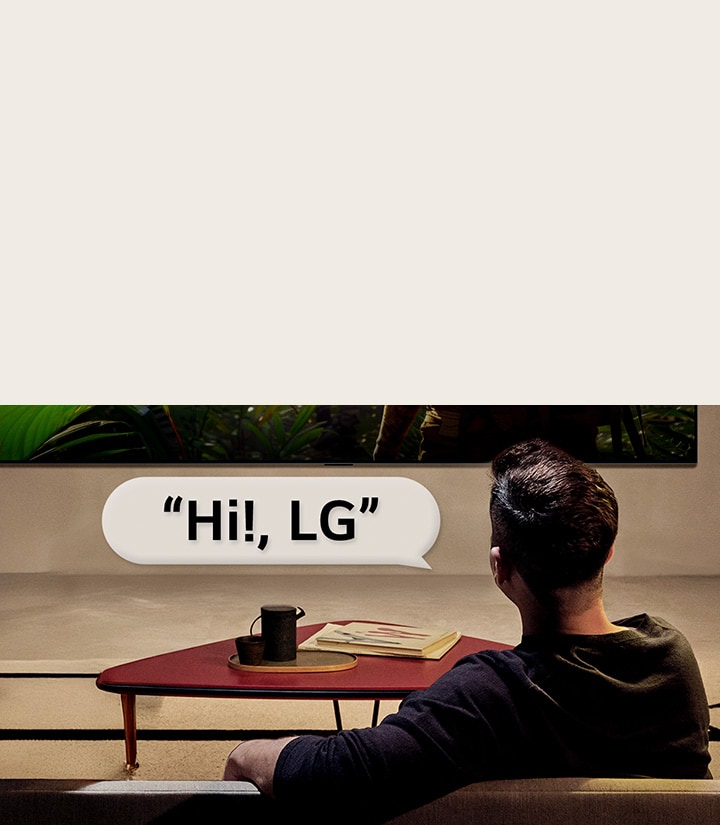 Personne dans son salon. Bulle de conversation autour d’eux montrant comment ils interagissent avec leur LG TV en disant simplement ??Hi LG??.