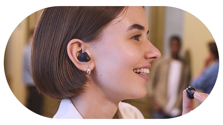 Une femme porte les écouteurs?T80S en utilise le mode chuchotement.