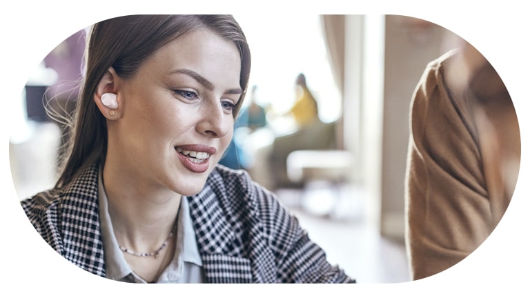 Une femme porte les écouteurs?T80S et utilise le mode conversation.