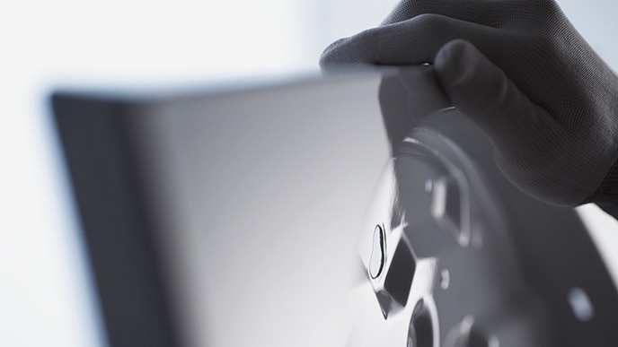 Eine Hand eines Handwerkers berührt den emaillierten K?rper der LG SIGNATURE Washing Machine.