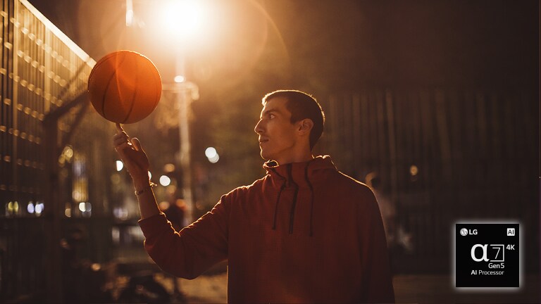Ein Mann auf einem n?chtlichen Basketballplatz l?sst einen Basketball auf seinem Finger kreisen