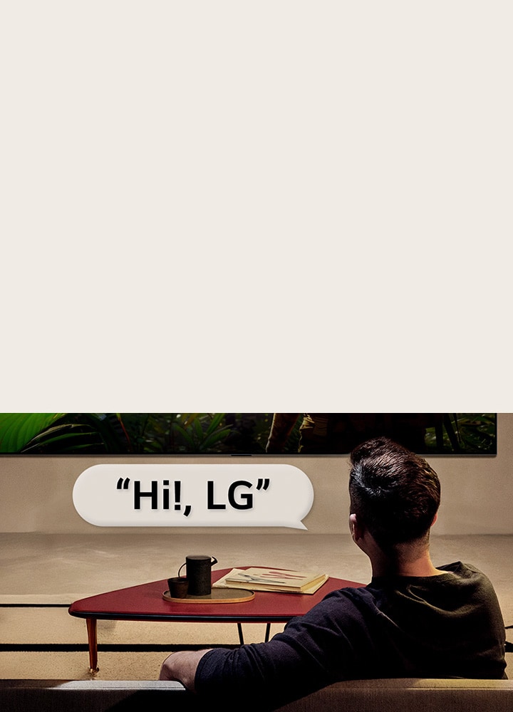 Une personne dans son salon. Une bulle de dialogue autour d’elle montre comment elle interagit avec sa LG TV en disant simplement ??Bonjour LG??.