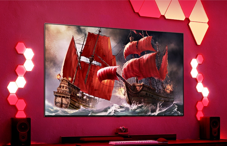 Ein QNED TV h?ngt an einer roten Wand und auf dem Bildschirm ist ein Piratenschiff zu sehen.