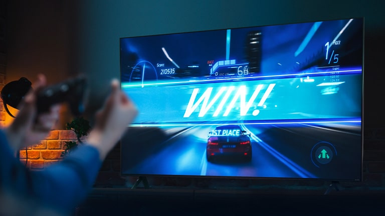 Un jeu de course automobile sur la ligne d’arrivée, avec le panneau indiquant ??WIN!??, alors que le joueur se cramponne au joystick du jeu. Les logos ALLM, eARC et HGiG sont placés dans le coin inférieur gauche.