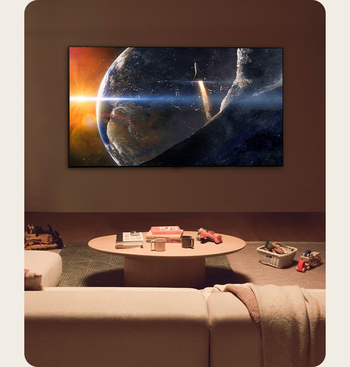 Una familia estaba sentada en el suelo de una sala de estar poco iluminada, junto a una peque?a mesa, mirando un televisor LG montado en la pared que mostraba la Tierra desde el espacio.
