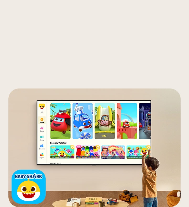 En liten pojke tittar p? Pinkfong p? en v?ggmonterad LG TV i ett vardagsrum med barnleksaker. 