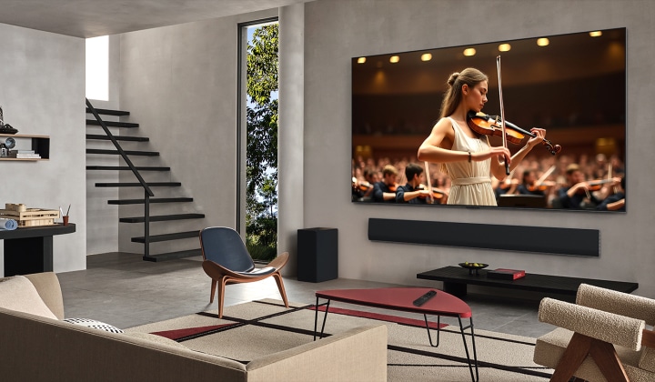 Obyvací pokoj s LG TV a LG Soundbarem. Na obrazovce se odehrává koncert. Vp?edu stojí houslistka a za ní orchestr. Z televizoru vycházejí soust?edné kruhy, které ukazují, jak technologie AI Acoustic Tuning skenuje místnost a p?izp?sobuje zvuk va?emu prostoru. 