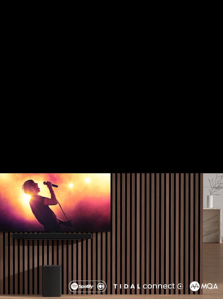 Televizor LG OLED C je umístěn na stěně, pod ním je p?ipevněn soundbar LG SC9S pomocí exkluzivního dr?áku. Subwoofer se nachází pod ním. Televizor zobrazuje koncertní scénu.