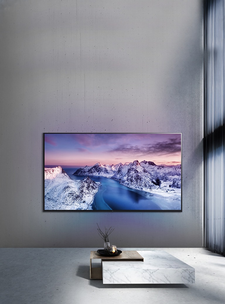 Ultra HD televizor namontovany na stěně za stolem s?dekoracemi ve stylu zen.