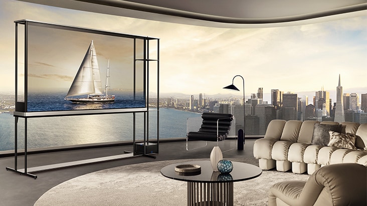 LG OLED T4 in einer Penthouse-Wohnung. Die Fenster geben den Blick auf die Skyline der Stadt und das Meer frei. Der LG OLED T4 zeigt im transparenten Modus das Bild einer Yacht. Durch die Position des Fernsehger?ts und die Transparenz des Bildschirms wirkt es, als würde die Yacht drau?en auf dem Meer schwimmen.