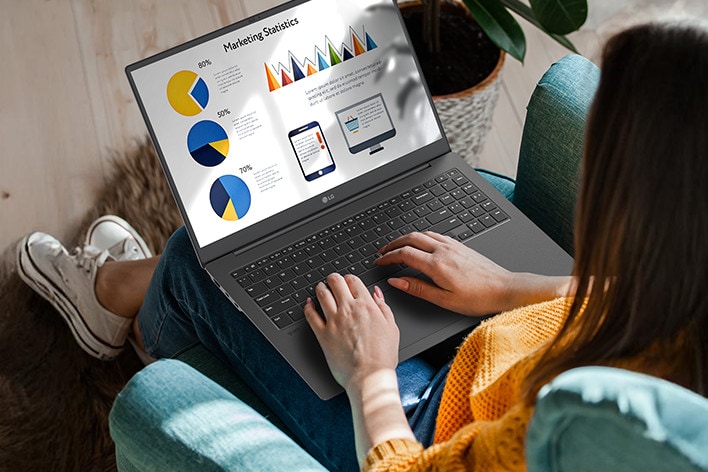 Eine Person sitzt bequem auf einem Stuhl und verwendet einen Laptop, auf dem eine Pr?sentation mit Diagrammen und Grafiken angezeigt wird. Eine Animation veranschaulicht den blendfreien Bildschirm, indem sie zeigt, dass selbst bei direkter Sonneneinstrahlung keine Lichtreflexion auftritt.