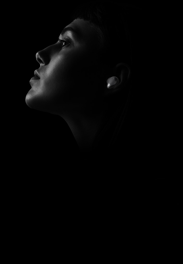 Das Schwarz-Wei?-Bild zeigt eine Frau, die ihre Musik mit den LG TONE Free T90S genie?t.