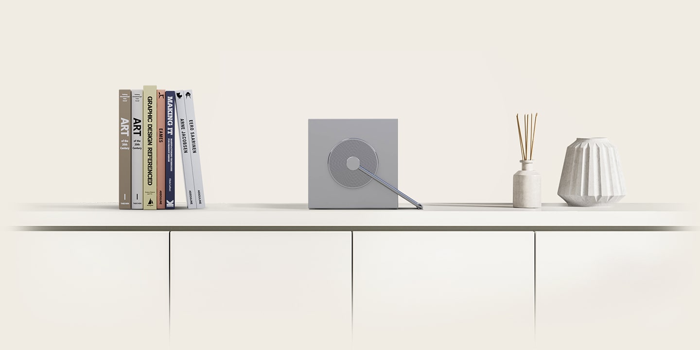 Mit einem Griff gleitet der CineBeam Q zur Seite und schrumpft allm?hlich. Auf der linken Seite kommt ein gr??eres Buch zum Vorschein, auf der rechten Seite zwei Vasen, die das kompakte Design unterstreichen.	