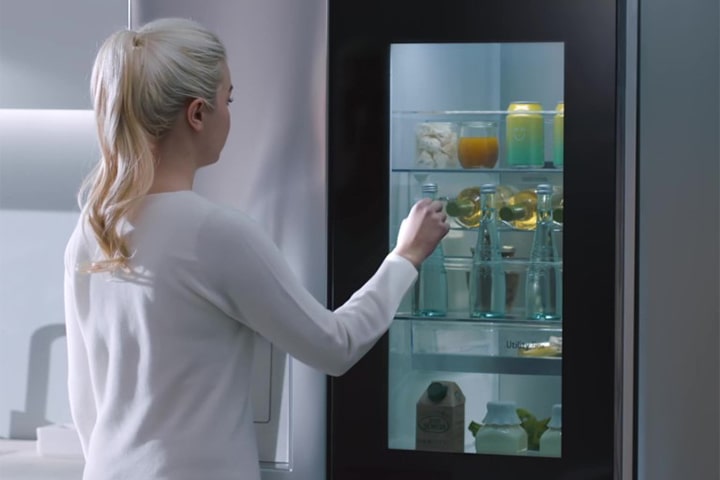 Ein Video zeigt eine Frau, die sich ihrem InstaView-Kühlschrank n?hert und zweimal klopft. Der Innenraum leuchtet auf. Sie kann den Inhalt ihres Kühlschranks sehen, ohne die Tür zu ?ffnen. Die Ansicht zoomt heran, um die Getr?nke in der Tür zu fokussieren. Anschlie?end zoomt sie heraus, um die Frau von hinten zu sehen, wie sie die Tür ?ffnet und sich ein Getr?nk nimmt.