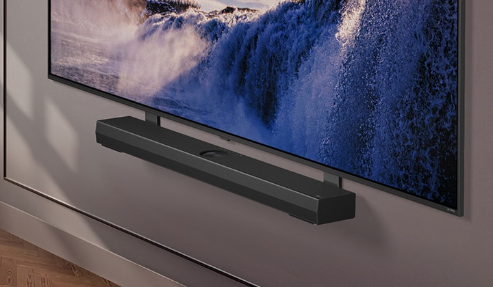 Die Synergy-Halterung wird mit einem LG QNED-Fernseher gezeigt. Die Synergy-Halterung und der LG QNED-Fernseher sind miteinander verbunden, w?hrend das Bild nach unten schwenkt, um die Unterseite des Fernsehers zu zeigen. Die LG Soundbar erscheint, da sie auf der Synergy-Halterung angebracht ist. Der Hintergrund wird durch die Wand gebildet.	