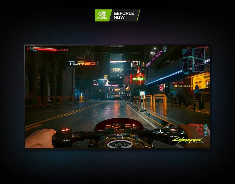 Escena de Cyberpunk 2077 que se muestra en la pantalla de un TV LG OLED, el jugador conduce una moto por una calle iluminada con luces de neón